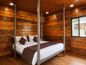 a bedroom with wooden walls and a bed with four posts at Royal Shouryas Resort in Kolhapur +55 photos