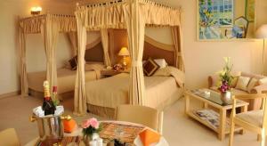a bedroom with two beds and a living room at Ohris Baseraa in Hyderabad