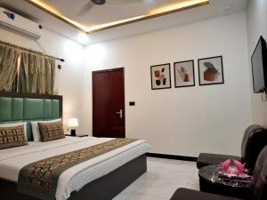 a bedroom with a bed and a living room at Galaxy Family Hotel Karachi Airport in Karachi +23 photos