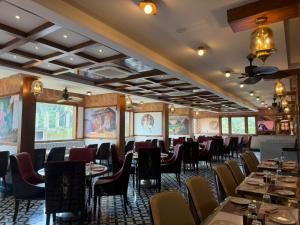 a restaurant with tables and chairs in a room at Hotel Mulki International in Mūlki