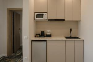 a kitchen with white cabinets and a microwave at Solara in Bishkek