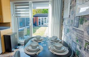 a dining room table with plates and dishes on it at The Cheshire ABode- Central Warrington- Stadium, Station Access- Sleeps 5 in Warrington