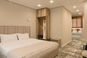 a bedroom with a large white bed and a window at Solara in Bishkek