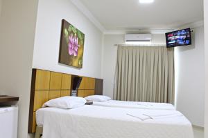 Postel nebo postele na pokoji v ubytování Dois Vizinhos Palace Hotel