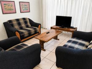 a living room with two couches and a television at Nut Tree Nook in Hazyview