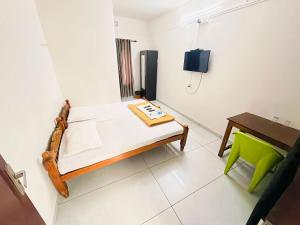 a room with a bed and a table and a chair at Apsara Residency in Perintalmanna