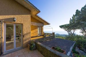 a house with a glass door and a balcony at Vista Mare by PosarelliVillas in Castiglione della Pescaia