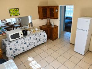 a kitchen with a table with a microwave and a refrigerator at Nut Tree Nook in Hazyview