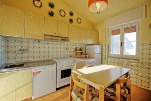 a kitchen with white appliances and a table in it at Vista Mare by PosarelliVillas in Castiglione della Pescaia