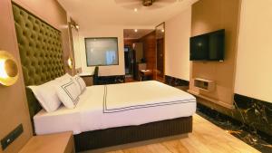 a hotel room with a bed and a television at Hotel Mulki International in Mūlki