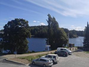 three cars parked in a parking lot next to a lake at Opera Magic Castle View, Air-Con, Free wifi in Savonlinna