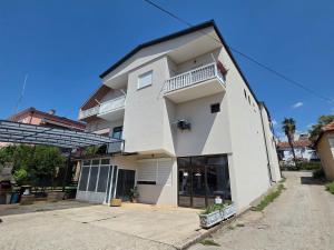 a white building with a window and a balcony at Apartman Centar in Grude
