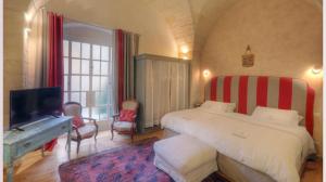 una camera con letto e TV a schermo piatto di B&B Palazzo Gorgoni a Lecce