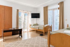 a bedroom with two beds and a desk and a tv at Bar Hotel Tirana in Kukës +15 photos