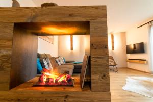 a living room with a fireplace in the middle of a room at Alpen-Lounge Apartment 17 Zillertal in Fügen