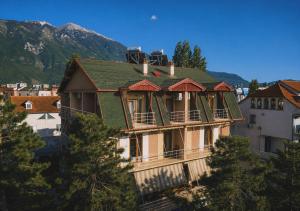 a large house with a green roof on a hill at Bar Hotel Tirana in Kukës