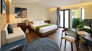 a hotel room with a bed and a desk and chair at Joi Home Beachfront in Vung Tau