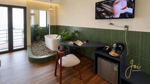 a bathroom with a tub and a table with a chair at Joi Home Beachfront in Vung Tau