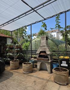 a patio with an outdoor oven with potted plants at Apartman Centar in Grude