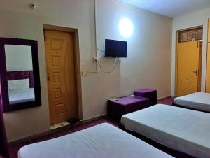a hotel room with two beds and a television at Eden Plus Executive Hotel Lahore in Lahore