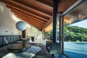a living room with a table and a pool at WEAZER 西伊豆 in Izu