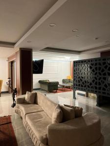 a living room with a couch and a tv at Nagas Premium Hotel in Yenişehir