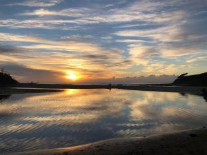 Ein Sonnenuntergang am Strand mit der Spiegelung der Wolken in der Unterkunft Cottages20 in Coffee Bay + 4 Fotos