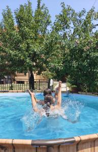 two people are laying in a swimming pool at Gaga Martinovo - Mountain House - Sauna & Pool in Martinovo