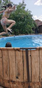 a young girl jumping into a swimming pool at Gaga Martinovo - Mountain House - Sauna & Pool in Martinovo +16 photos