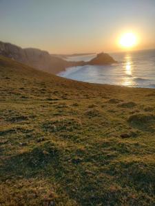 ein Sonnenuntergang an einem Strand mit dem Meer in der Unterkunft Cottages20 in Coffee Bay