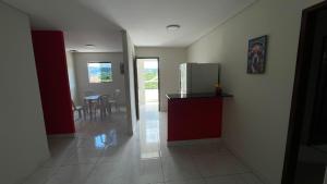 a kitchen with a refrigerator and a table with chairs at Pousada Horizontes de Bonito Apto in Bonito +7 photos