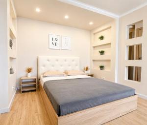 a bedroom with a large bed and shelves at Габдуллина 79 in Kokshetau