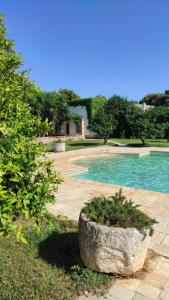 a large stone planter next to a swimming pool at Masseria Incantalupi in San Vito dei Normanni