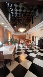 a restaurant with a black and white checkered floor at готель ДежаВю in Berdychiv