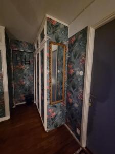 a hallway with a mirror and floral wallpaper at Villa Signedal Hostel in Kvidinge +83 photos