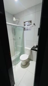 a bathroom with a toilet and a glass shower at Pousada Horizontes de Bonito Apto in Bonito
