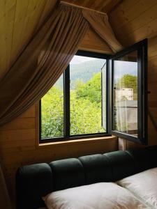 a room with a window with a couch and a view at Gerlik Cottage in Mestia