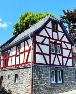 a half timberedbered house with red and white at Fachwerkhaus Rosengärtchen by Vulkaneifel-Chalets in Kottenheim