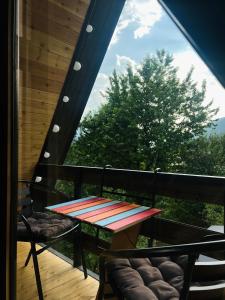 a table and chairs on the balcony of a house at Gerlik Cottage in Mestia