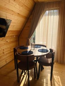 a dining room with a table and chairs and a window at Gerlik Cottage in Mestia