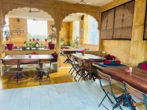 a restaurant with tables and chairs in a room at Hotel Pol Haveli Jaisalmer in Jaisalmer