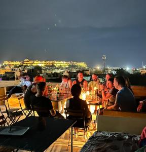 a group of people sitting at tables on a roof at Hotel Pol Haveli Jaisalmer in Jaisalmer