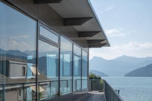 a house with a view of the water and mountains at Seminar-Hotel Rigi am See in Weggis