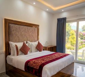 a bedroom with a large bed with a large window at Heera Lodge Kasauli By Evening Sky Hotel in Kasauli