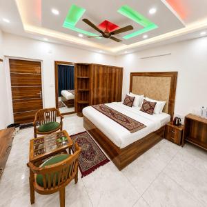a hotel room with a bed and a table at Heera Lodge Kasauli By Evening Sky Hotel in Kasauli +4 photos