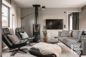 a living room with a couch and a chair at Black Grouse Lodge in Tällberg