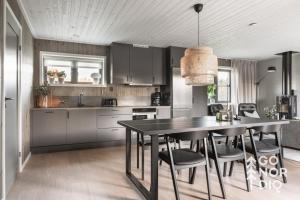 a kitchen with a black table and some chairs at Black Grouse Lodge in Tällberg