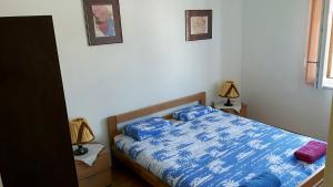 sypialnia z niebieskim łóżkiem i 2 niebieskimi poduszkami w obiekcie Island Paradise Apartment w mieście Kukljica