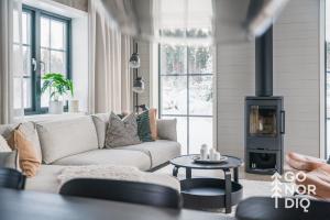 a living room with a couch and a wood stove at The Black Bear Lodge in Tällberg