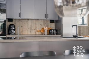 a kitchen with white cabinets and a counter top at The Black Bear Lodge in Tällberg